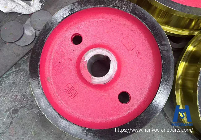 Close-up of a forged crane wheel showing hardened tread, machined bore, and hub detail