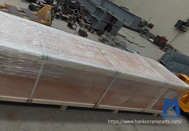 Wooden-crate-with-crane-end-beams-wrapped-in-stretch-film-and-steel-straps-on-a-pallet